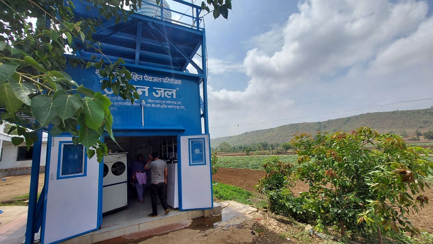 The Jeevan Jal fluoride removal kiosk in Dhar district, Madhya Pradesh, doors open with operators inside.