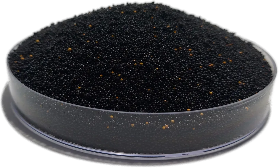 Black HIX-Nano 100+ arsenic removal resin beads flecked with amber, heaped in a laboratory dish.