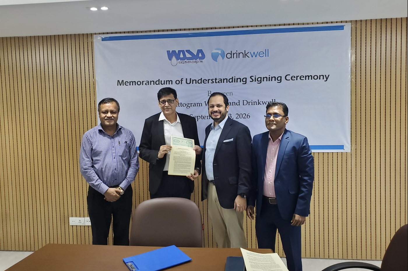Chattogram WASA Managing Director Selim Md Jane Alam and Drinkwell CEO Minhaj Chowdhury hold the signed MoU under the ceremony banner, Chattogram WASA boardroom, 13 September 2026.